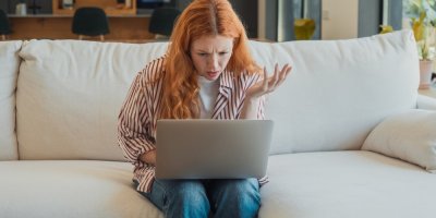 Frustrovaná mladá žena se dívá do notebooku