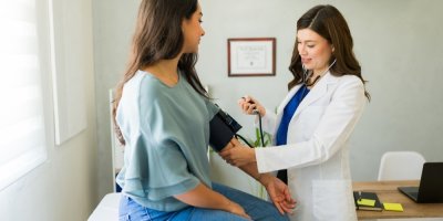 Doktorka měří pacientce krevní tlak