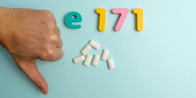 Žvýkačky obsahující oxid titaničitý (E171), ruka ukazující palec dolů