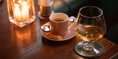 Alkohol ve skleničce, káva v hrnku