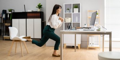 Žena provádí pohybové cvičení v kanceláři