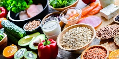 Zdravé potraviny včetně ovesných vloček, luštěnin, ryb, ovoce, zeleniny a tofu 