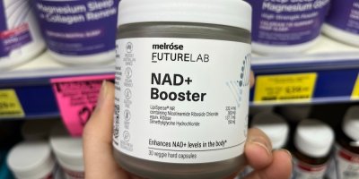 Ženská ruka držící doplněk stravy Melrose Futurelab NAD+ Booster v produktovém balení