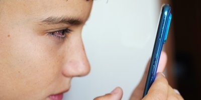 Chlapec se dívá zblízka do mobilního telefonu