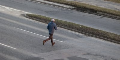 Muž běžící přes silnici