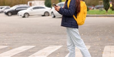 Dívka na přechodu s mobilním telefonem 