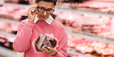 Zákaznice si v supermarketu prohlíží balení syrového masa