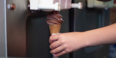 Dívka plní kornoutek točenou zmrzlinou