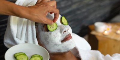 Žena si přikládá na oči kolečka okurky