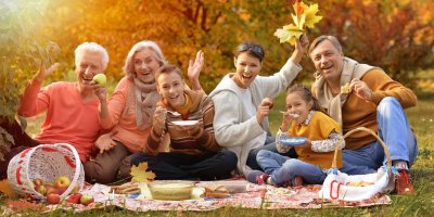 Rodina drží podzimní listí na pikniku