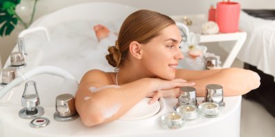 Žena se koupe ve vaně s pěnou a relaxuje