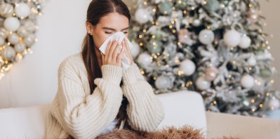 Žena smrká do kapesníku u vánočního stromku