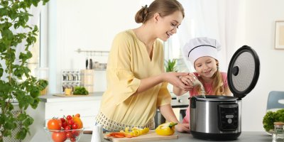 Žena vaří s dcerou v rýžovaru