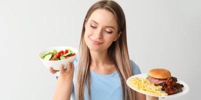Žena si vybírá ze zdravých a nezdravých potravin