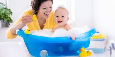 Žena koupe miminko ve vaničce