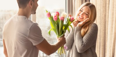 Mladý muž předává mladé ženě kytici tulipánů
