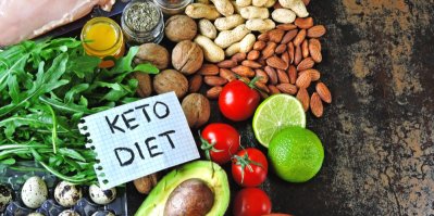 Avokádo, rajčata, ořechy, limetka, rukola, vejce, papír s nápisem Keto diet