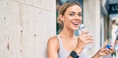 Žena pije v létě vodu z PET lahve
