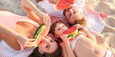 Rodina na pláži jí vodní meloun