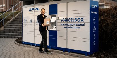 Muž s balíkem stojí před nově zavedeným PPL Parcelboxem