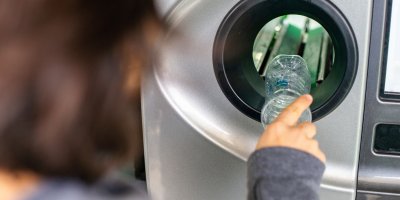 Žena vrací PET lahev do sběrného automatu