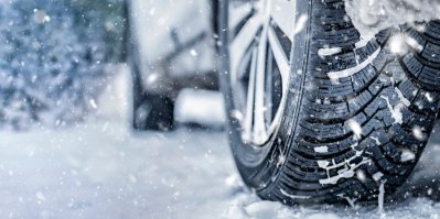 Zimní pneumatika na autě v poprašku sněhu