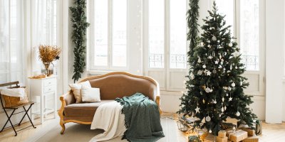 Ozdobený vánoční stromek s dárky, vedle křeslo