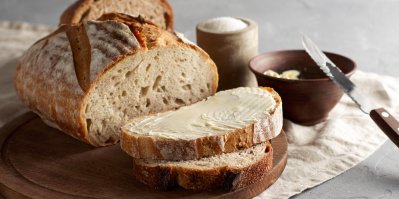 Bochník chleba, částečně nakrájený s máslem
