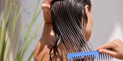 Žena, která si rozčesává umyté vlasy