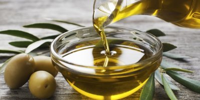 Nalévání olivového oleje z láhve do misky