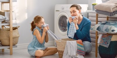 Matka s dcerou uklízí prádlo z pračky