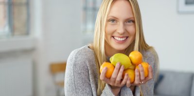 Žena drží v ruce citrony a mandarinky