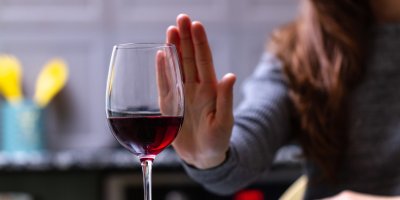 Žena odmítá sklenici vína