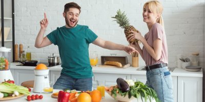 Muž a žena se baví v kuchyni s veganskými ingrediencemi