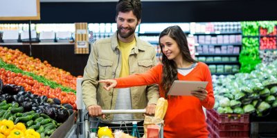 Pár nakupuje v supermarketu s tabletem