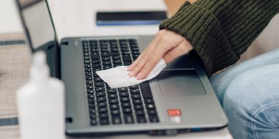 Žena čistí klávesnici notebooku