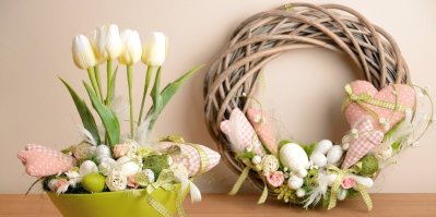Jarní dekorace: vajíčka, soška ptáka, krmítko, rozkvetlé květiny ve váze