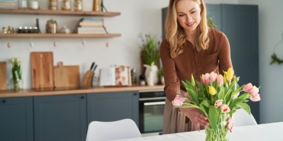 Žena upravuje kytici tulipánů v květináči