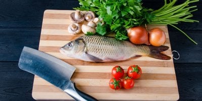 Ryba se zeleninou na prkénku se sekáčkem