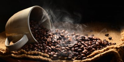 Šálek s čerstvě vypraženými kávovými zrny