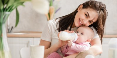 Maminka krmí svoje dítě sunarem v lahvičce