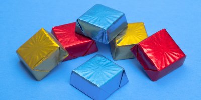 Šest kostiček ledové čokolády v modrém, zlatém a červeném obalu