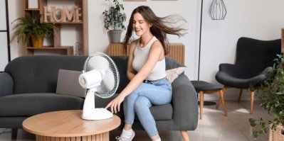 Žena se ochlazuje stolním ventilátorem