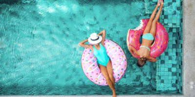 Dvě ženy leží na nafukovacích kruzích v bazénu