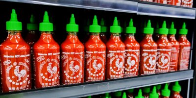 Lahve omáčky Sriracha v regálu v supermarketu