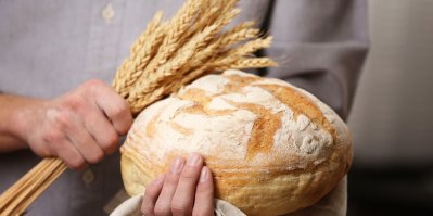 Žena drží chléb a pšenici