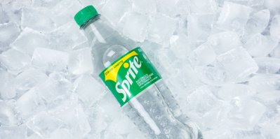 Průhledná lahev od limonády Sprite položená na ledu