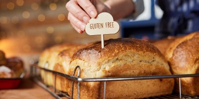 Pekař zapichuje cedulku s nápisem gluten free do pečiva