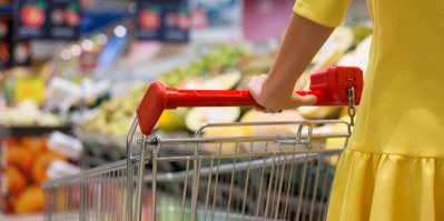 Žena tlačí nákupní vozík v supermarketu