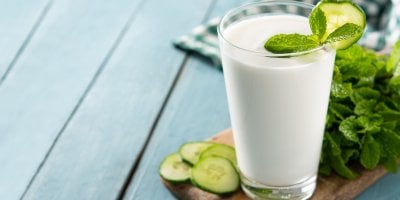 Ayran ve sklenici, která je ozdobená kolečkem okurky a mátou